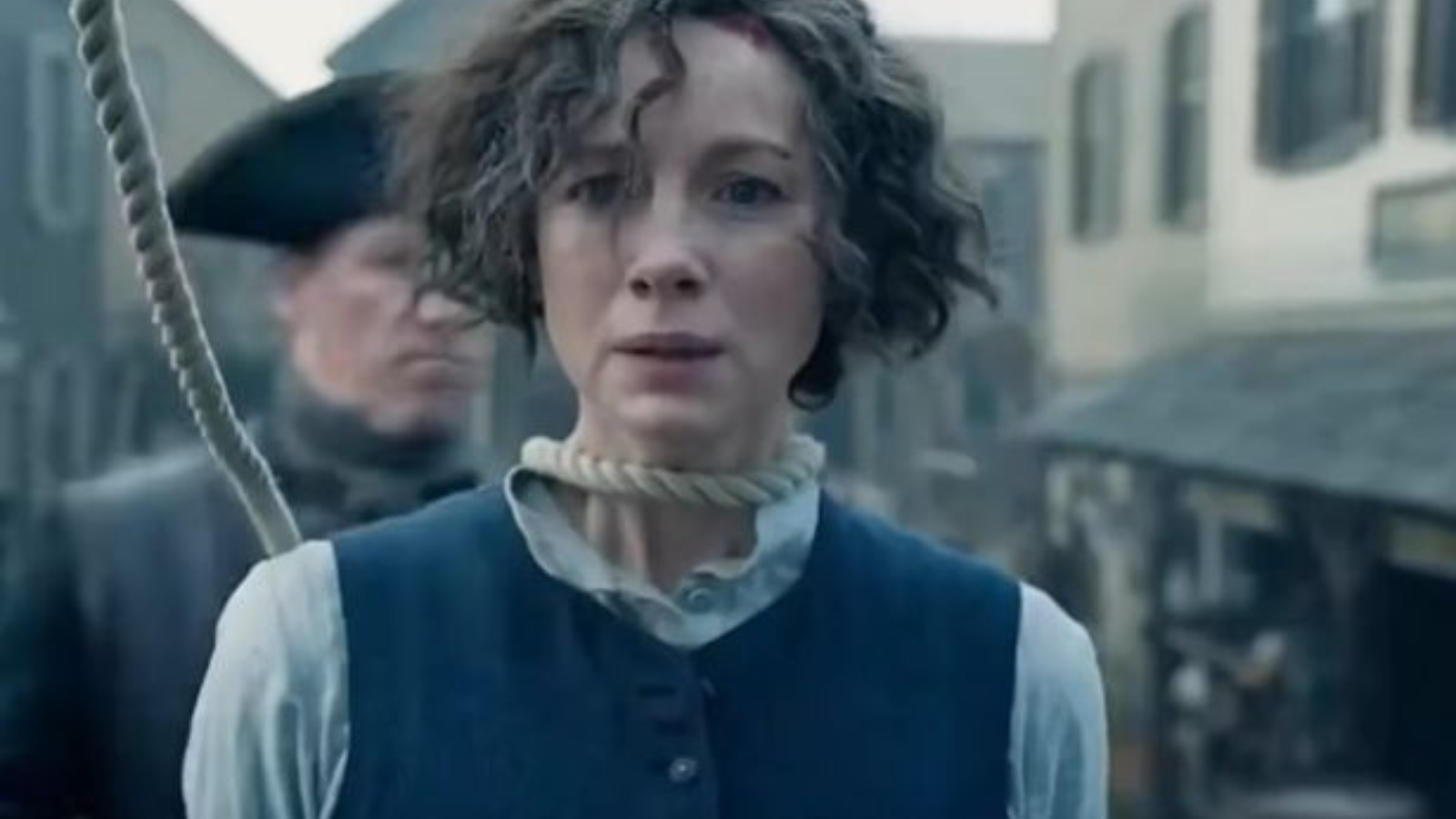 A mortified Claire Fraser (Caitriona Balfe) heroine of the fictional series Outlander standing on the scaffold with a noos aroun her neck.